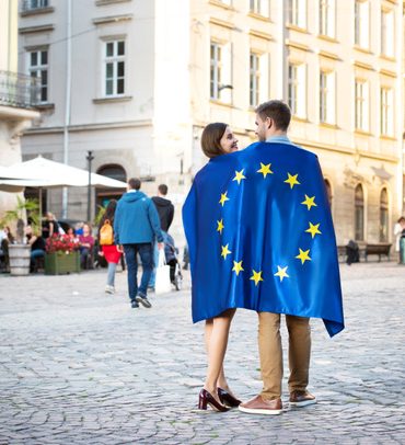 stock-photo-couple-young-tourists-wrapped-flag-european-union-standing-city-square